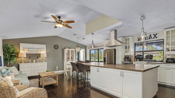 A spacious kitchen with a large island, white cabinetry, and a ceiling fan. - Canal-front Oasis w/ Dock & Kayaks in Cape Coral! (Cape Coral)