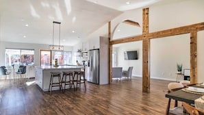 A spacious kitchen with a central island, wooden beams, and a large window. - 2 Mi to Coachella: Indio Getaway w/ Outdoor Oasis! (Indio)