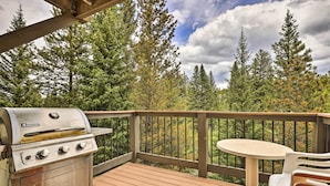 A deck with a stainless steel grill, a round table, and chairs. - Walk to Ski Lift: Breckenridge Retreat w/ 2 Decks! (Breckenridge)