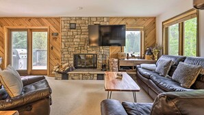A cozy living room with a stone fireplace, leather sofas, and a flat-screen TV. - Walk to Ski Lift: Breckenridge Retreat w/ 2 Decks! (Breckenridge)