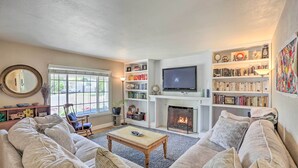 Ein Wohnzimmer mit Kamin, Fernseher und Bücherregal.