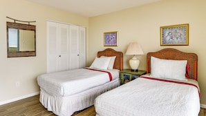A room with two beds, a wardrobe, a mirror, and two wall-mounted pictures. - Beachfront Marco Island Condo w/ Pool Access! (Marco Island)