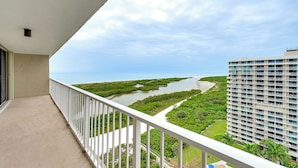 A balcony with a view of a river, greenery, and a building. - Beachfront Marco Island Condo w/ Pool Access! (Marco Island)