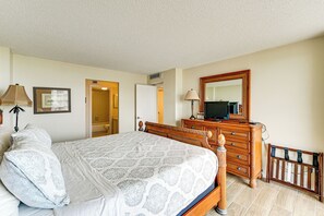 A bedroom with a bed, dresser, mirror, and a crib. - Beachfront Marco Island Condo w/ Pool Access! (Marco Island)