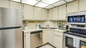 A kitchen with a refrigerator, dishwasher, microwave, toaster, and oven. - Beachfront Marco Island Condo w/ Pool Access! (Marco Island)