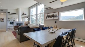 Un espace repas moderne, doté d’une grande table, de chaises et d’un ventilateur de plafond.