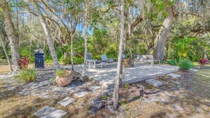 A patio area with outdoor furniture, a fire pit, and a stone pathway. - 'laurel on the Lakes' Floral City Escape w/ Canoe! (Floral City)
