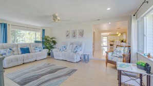 A spacious living room with a sofa, armchair, and a dining table. - 'laurel on the Lakes' Floral City Escape w/ Canoe! (Floral City)