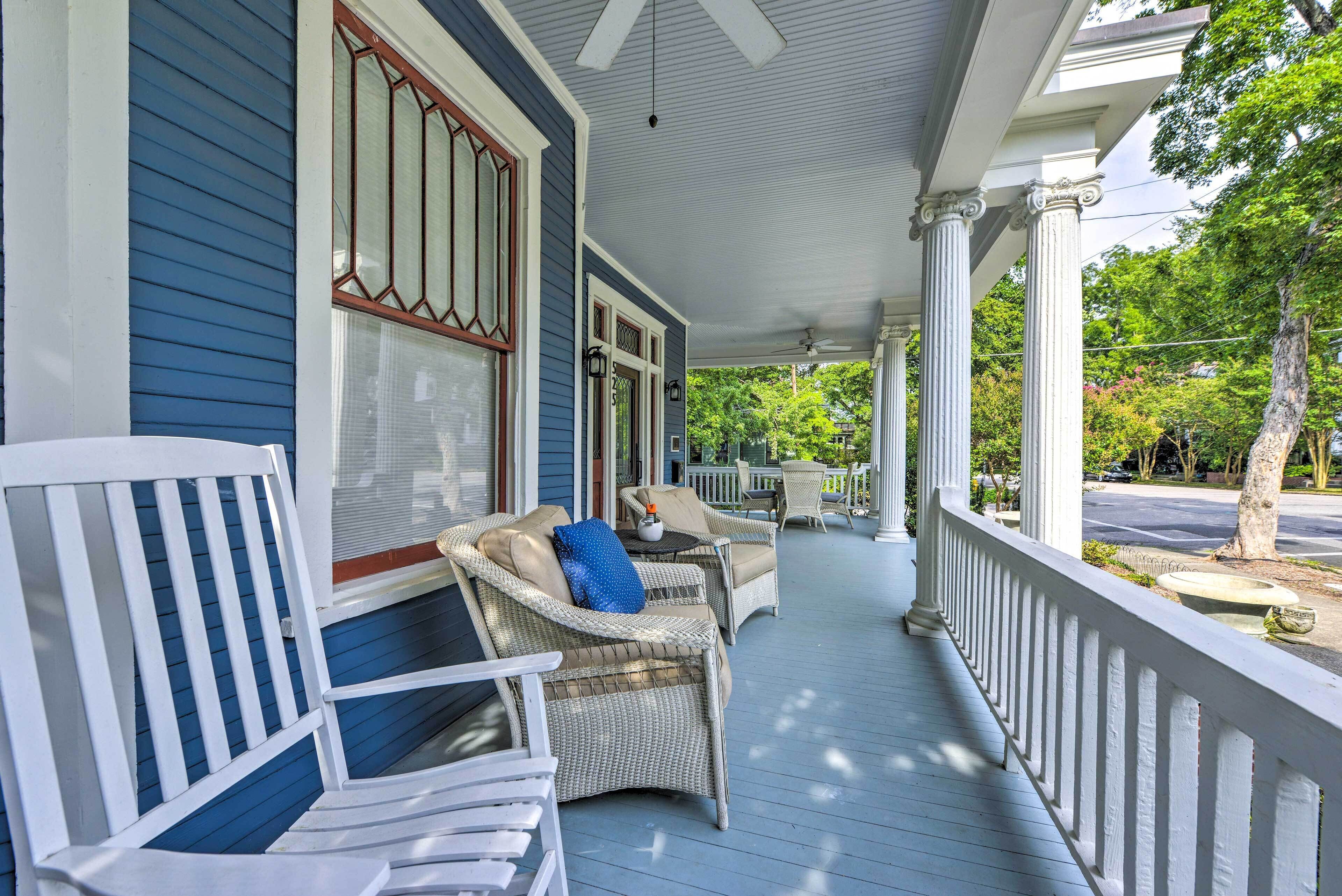 A covered porch with wicker furniture and a white railing.