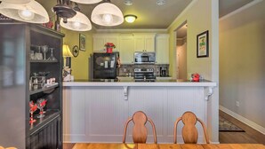 A kitchen with a central island, white cabinetry, and pendant lighting.
