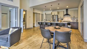 A modern kitchen with a central island, dark chairs, and a round table. - Condo w/ Mountain Views in Heart of Downtown! (Winter Park)