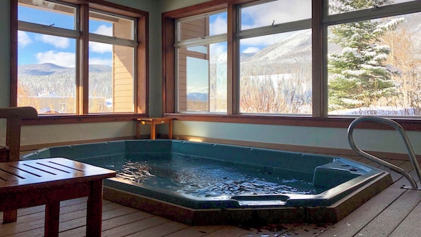 A hot tub in a room with large windows overlooking a snowy landscape. - Condo w/ Views & Hot Tub Access in Silverthorne! (Silverthorne)