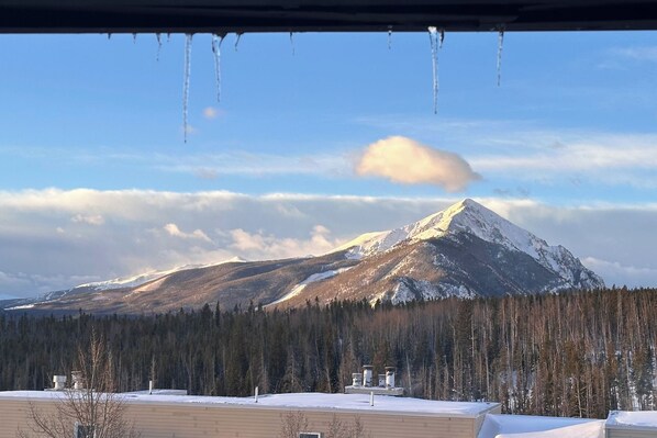 A snow-covered mountain with a clear sky and icicles hanging from a roof. - Condo w/ Views & Hot Tub Access in Silverthorne! (Silverthorne)
