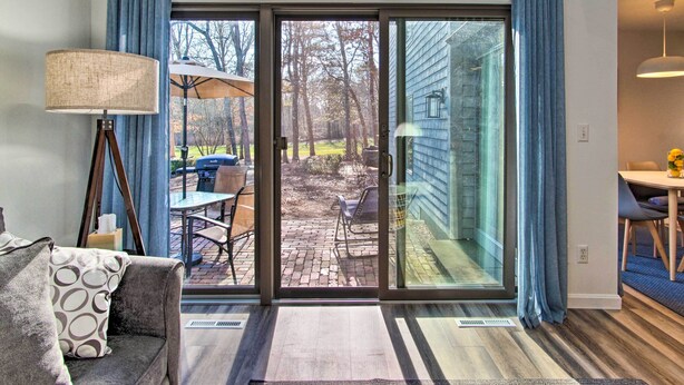 Un salon moderne doté d’une porte-fenêtre coulissante donnant sur un patio.