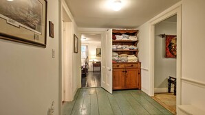 A hallway with a wooden cabinet and a door leading to a room. - Historic Huntington Home - Walk to Westfield River (Huntington)