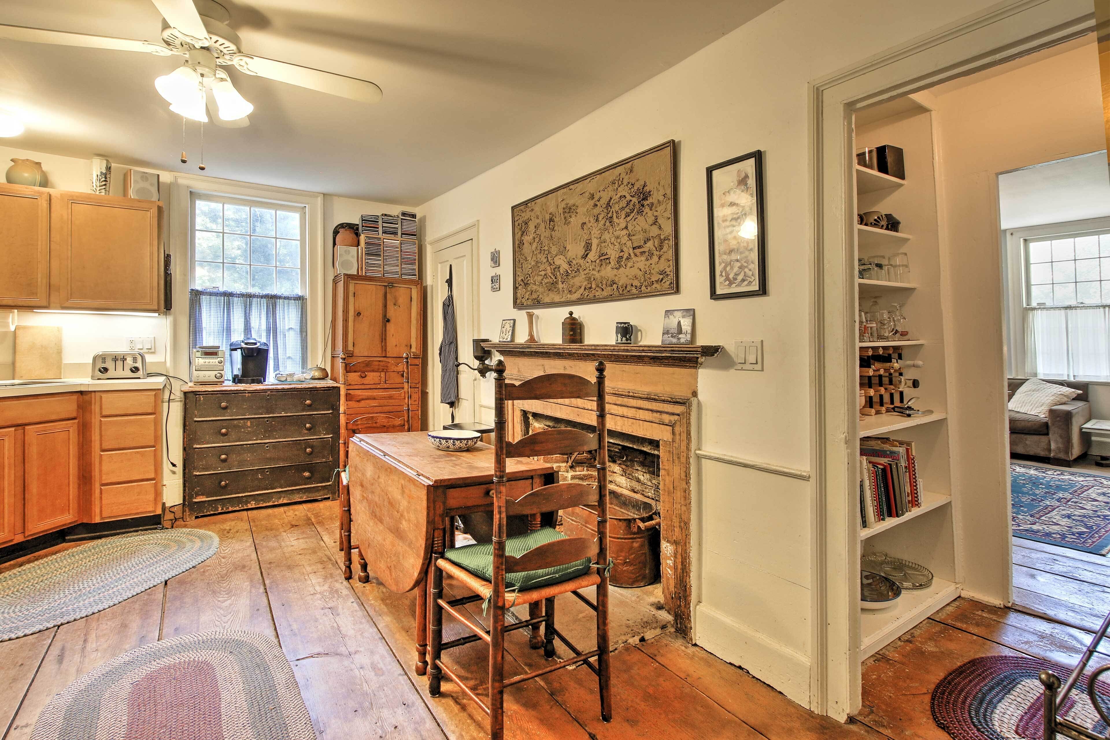 A traditional kitchen with wooden cabinets, a dining table, and a fireplace.