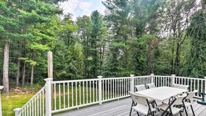 A deck with a white railing, surrounded by a forest. - Granby Home w/ Deck < 1/2 Mi to Aldrich Lake! (Granby)