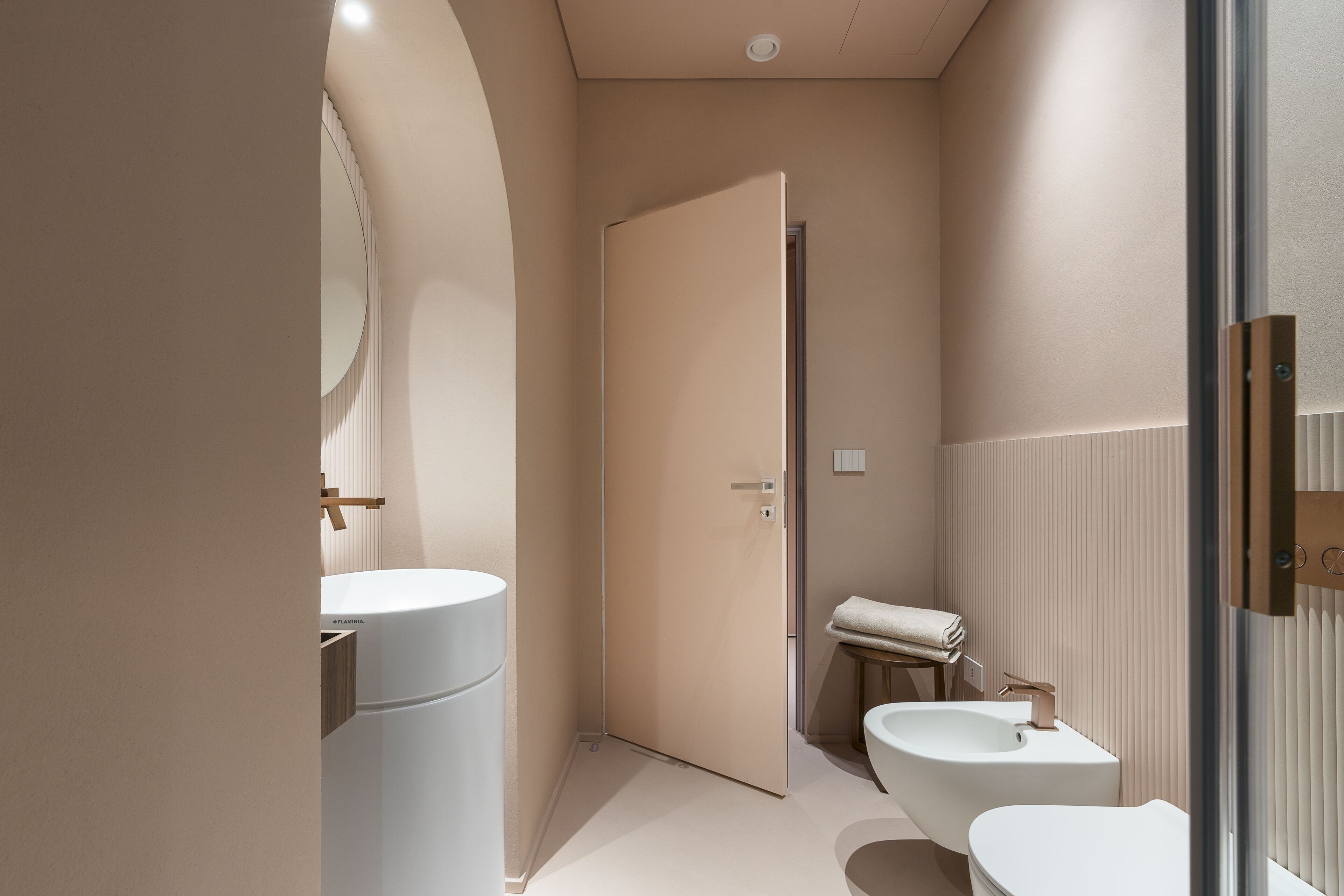 A modern bathroom with a toilet, bidet, and sink.