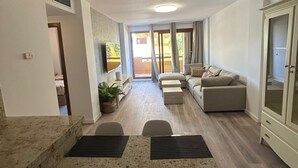 A spacious living area with a dining table, sofas, and a view through a glass door to an outdoor patio. - Oasis of Peace in Torrevieja – Luxury Residence, 3 Pools & 2 min from the Sea (Torrevieja)