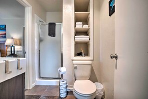 A bathroom with a toilet, a shower, and a towel rack. - Brookings Vacation Rental Studio - Walk to Town! (Brookings)