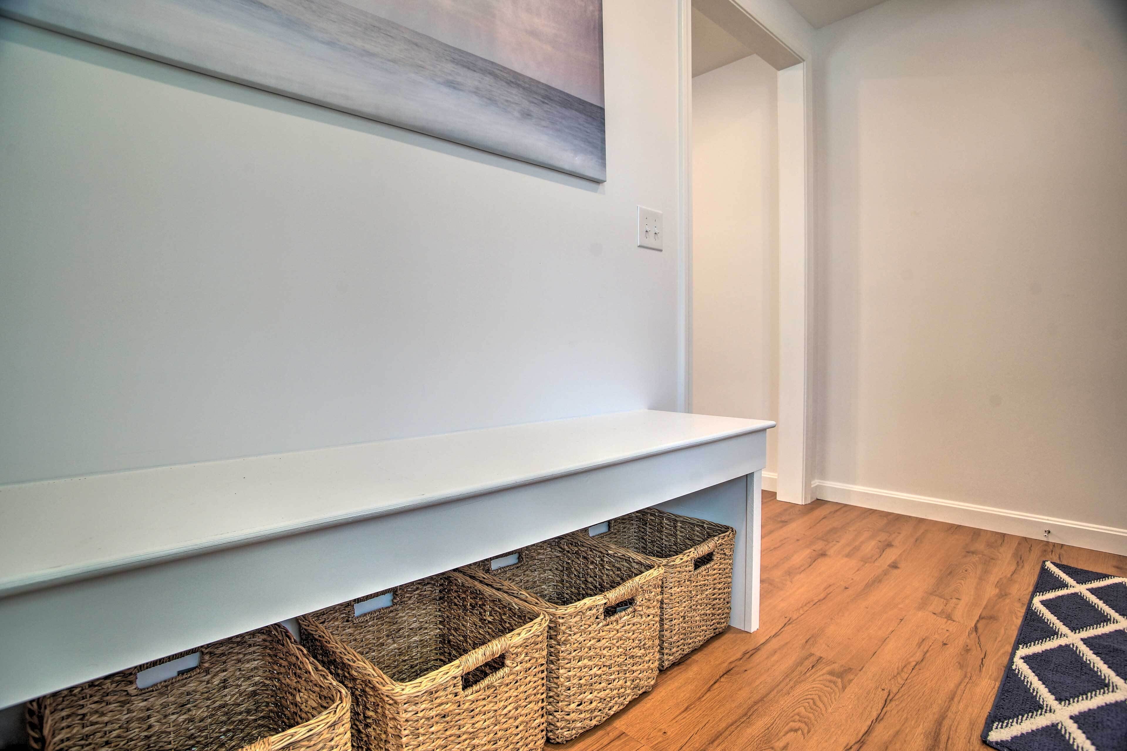 A hallway with a light blue wall, a wooden floor, and a blue and white rug.