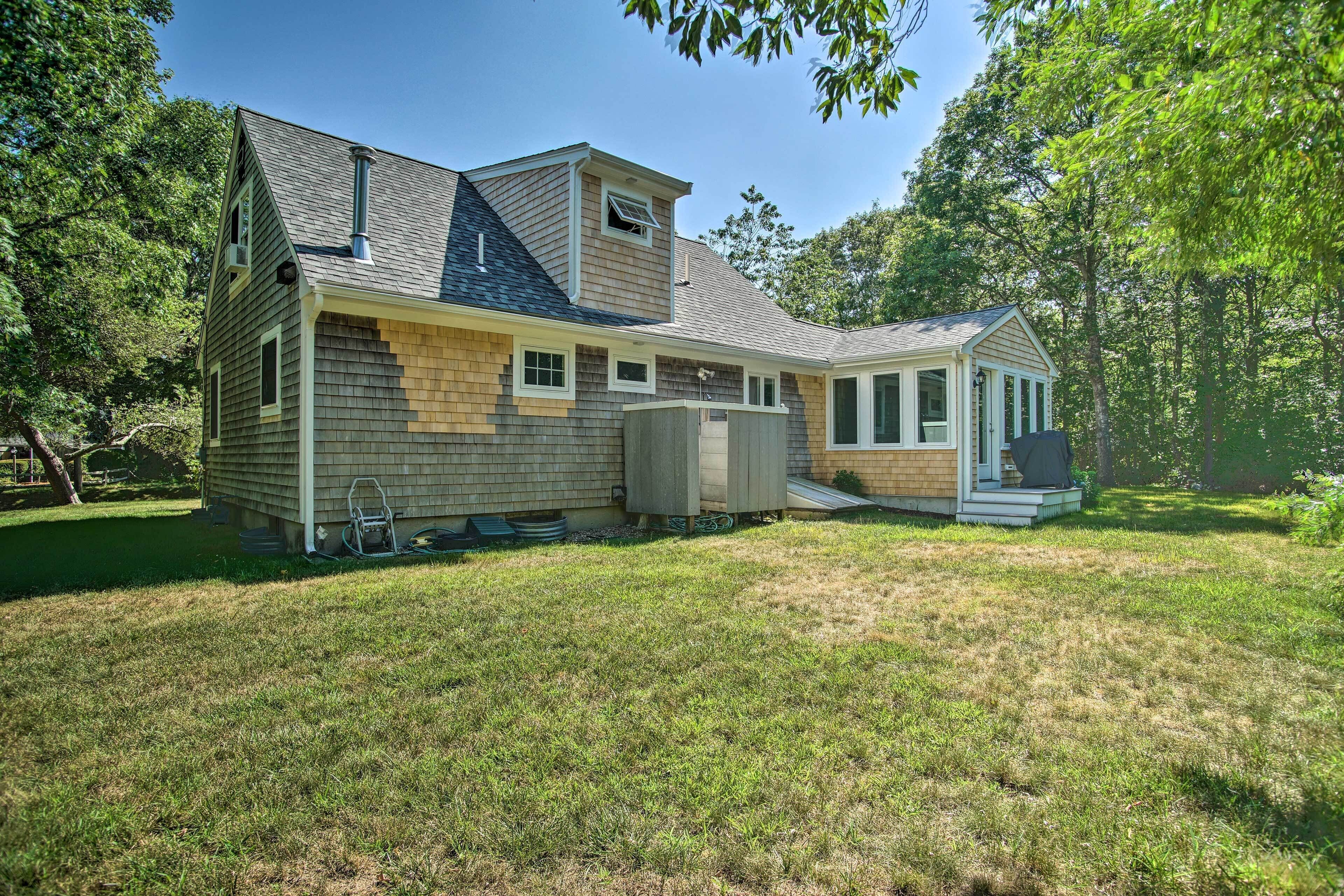 A two-story house with a large front yard, a covered porch, and a chimney.