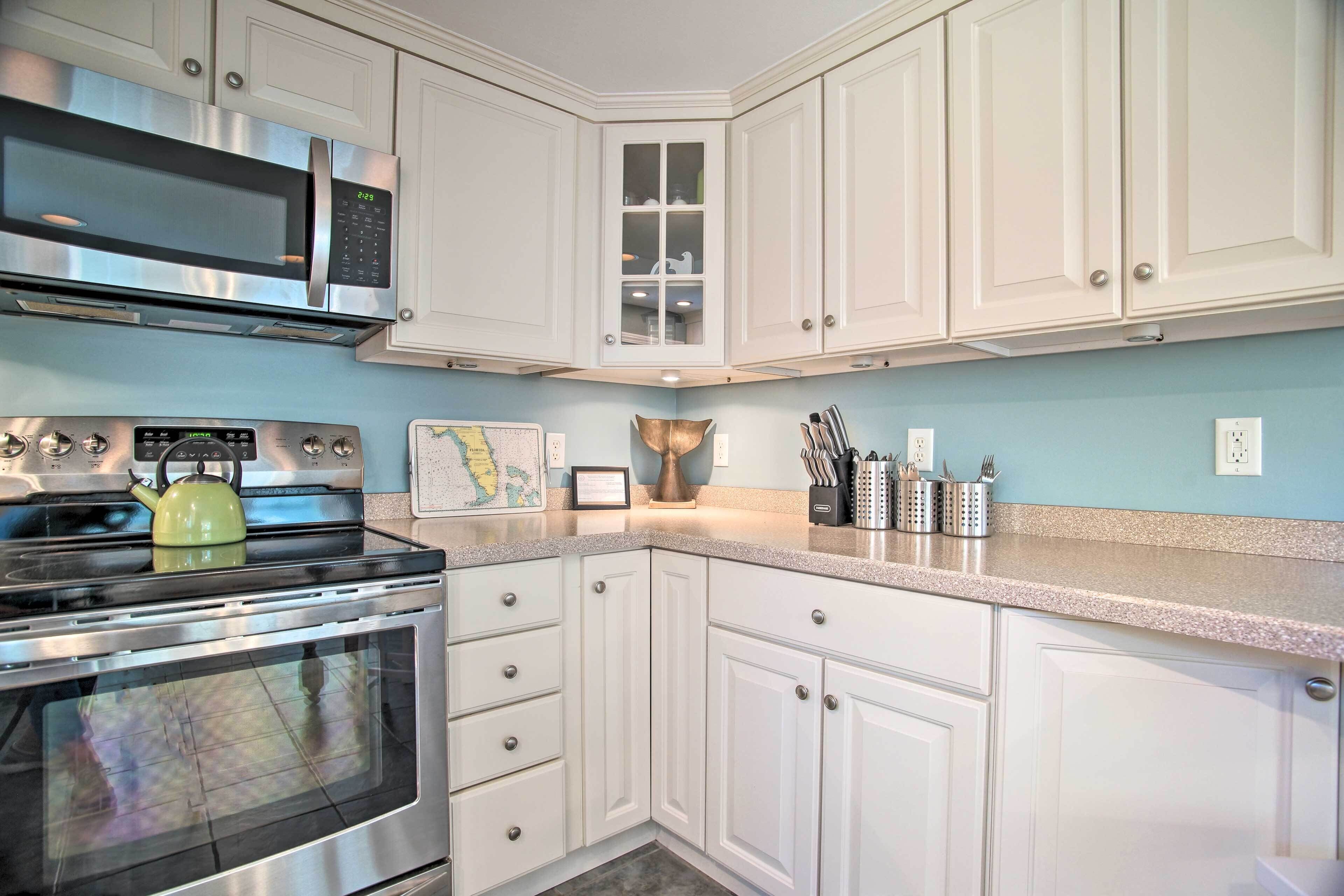 A kitchen with white cabinets, stainless steel appliances, and a granite countertop.