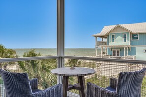 A balcony with wicker furniture and a view of the ocean. - Luxe Beachfront Windmark Cottage w/ Deck! (Port St. Joe)