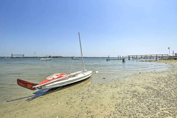 Un bateau nommé « Sunfish » est amarré sur une plage de galets, avec une jetée en arrière-plan.