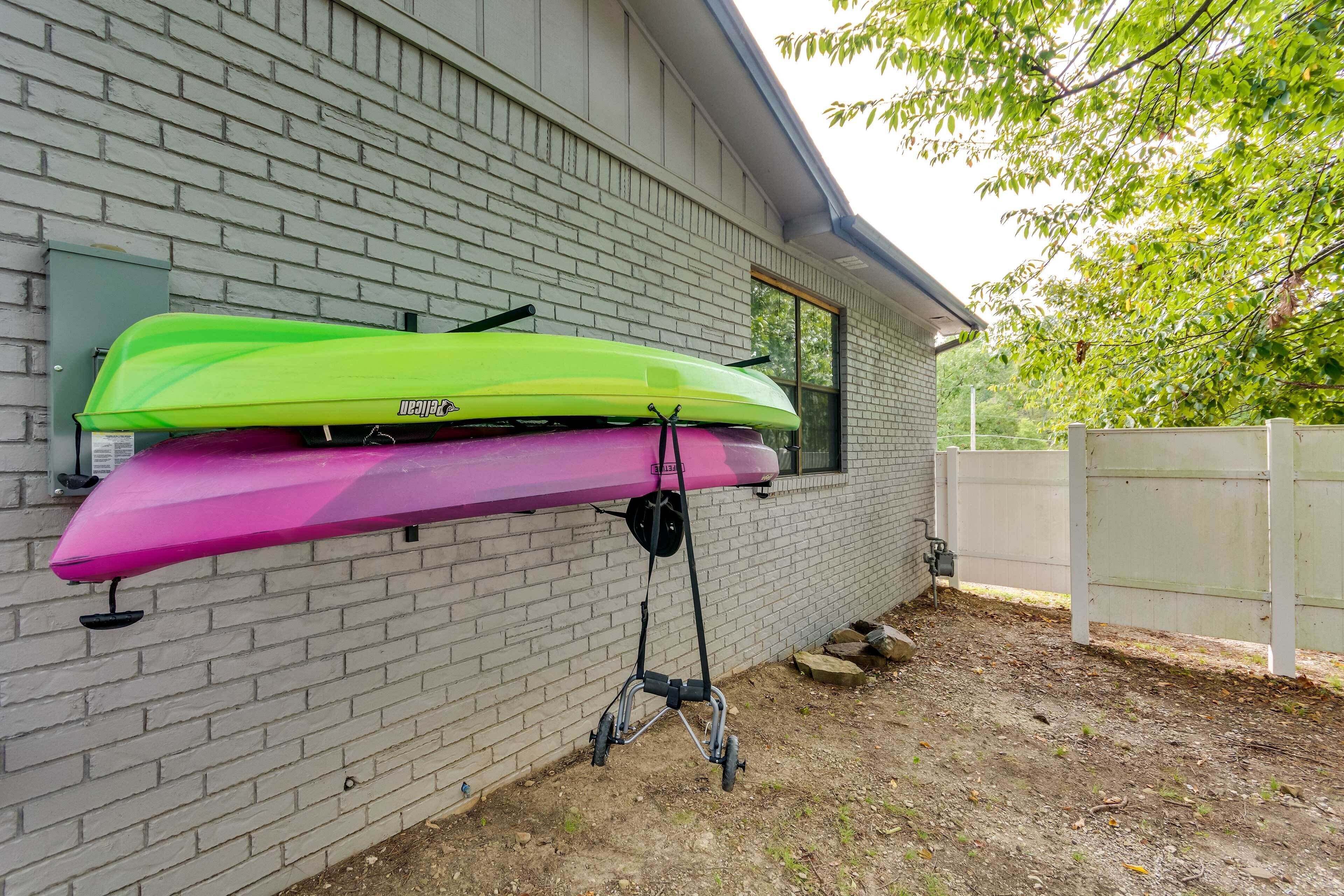 Deux kayaks fixés à un mur, près d’une fenêtre et d’une clôture blanche.