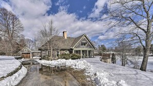 A large house with a stone foundation, a wooden garage, and a driveway leading to a snow-covered path. - Waterfront Ipswich Escape: 2 Miles to Crane Beach! (Ipswich)