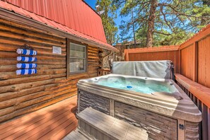 A hot tub in a log cabin with a stone facade and a wooden deck. - Rustic Ruidoso Log Cabin With Hot Tub & Deck! (Ruidoso)