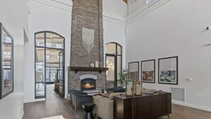 Amplia sala de estar con chimenea, muebles modernos y obras de arte en las paredes.