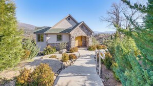 A stone house with a sloped roof, a front porch, and a pathway leading to the entrance. - 28 Mi to Yosemite: Lovely Mtn Cottage w/ Deck! (North Fork)
