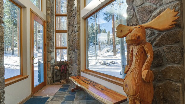 A wooden bench in a room with stone walls and large windows overlooking a snowy outdoor area. - Near Ski Access: Home w/ Hot Tub in Breck! (Breckenridge)