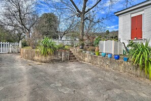 A concrete courtyard with a white picket fence, a concrete wall with potted plants, and a red shuttered building. - Near Dtwn & Bathhouses! Family Hub in Hot Springs (Hot Springs)
