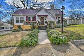 A single-story house with a front porch, a chimney, and a small deck.