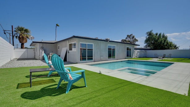 A modern house with a swimming pool, a patio with a chair, and a well-maintained lawn. - Pool & Mountain Views: Palm Springs Home (Palm Springs)