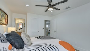 A bedroom with a large bed, a ceiling fan, and a door leading to another room. - Pool & Mountain Views: Palm Springs Home (Palm Springs)