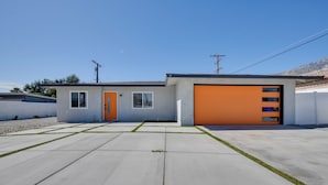 A modern house with a garage, a small porch, and a clear sky. - Pool & Mountain Views: Palm Springs Home (Palm Springs)