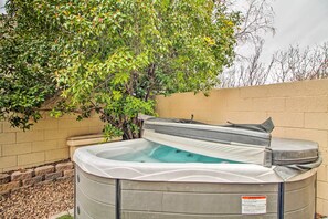 A hot tub in a backyard with a brick wall and a tree. - Albuquerque Vacation Home Rental w/ Hot Tub! (Albuquerque)