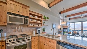 A modern kitchen with wooden cabinets, stainless steel appliances, and a large island. - Walkable Park Mountain Getaway: Hot Tub & Views! (Park City)