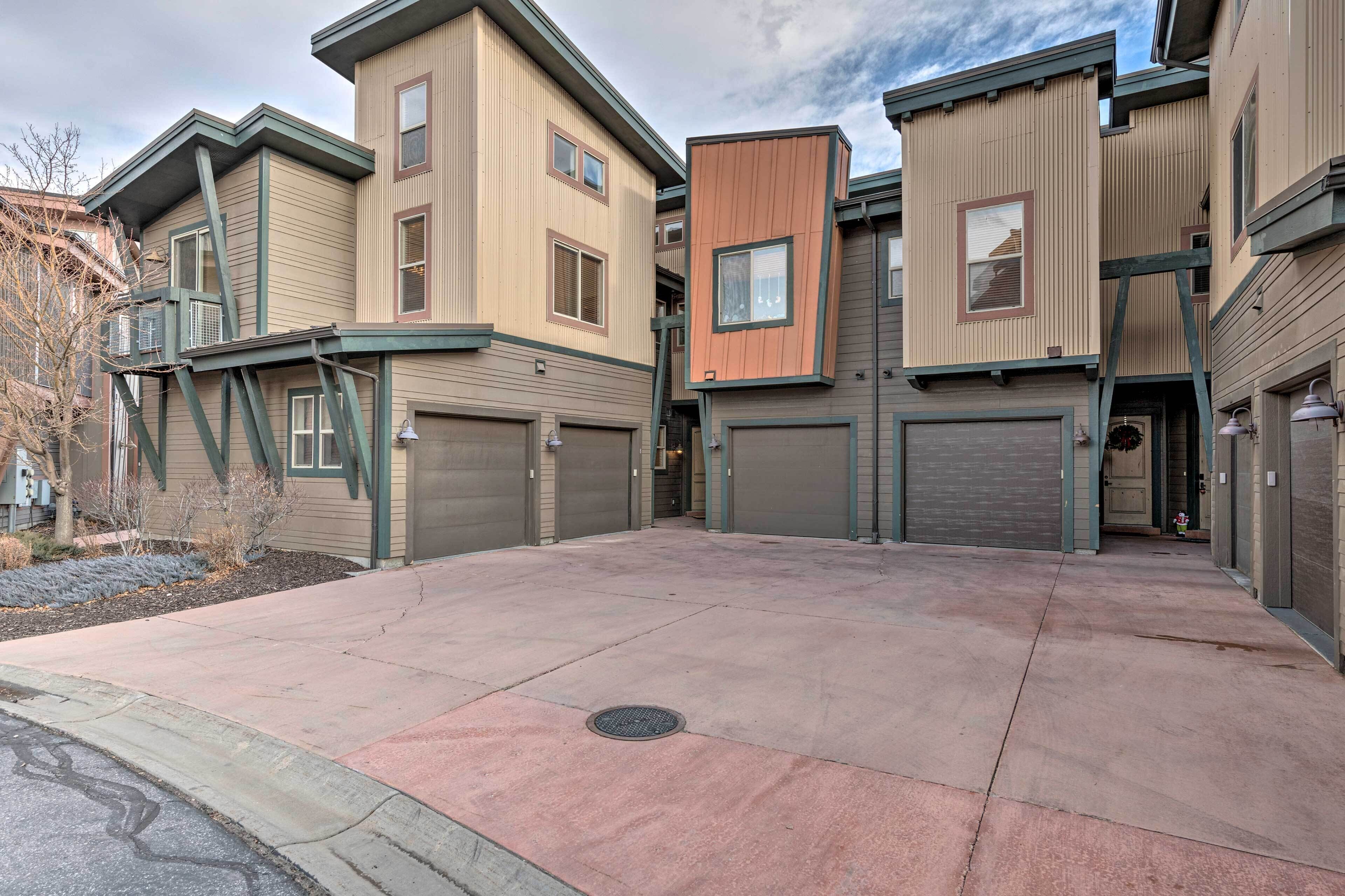A row of modern townhouses with attached garages and a central courtyard.