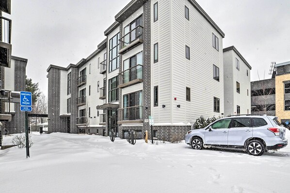 A multi-story residential building with a parking area in front. - Traverse City Condo: Half Mi to Front Street! (Traverse City)