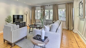 A modern living room with a sofa, TV, and a decorative vase on a wooden table.