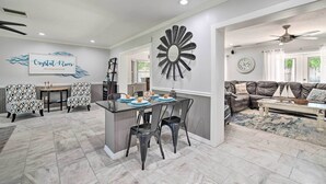 A modern living room with a dining area, featuring a large mirror, a sofa, and a coffee table.