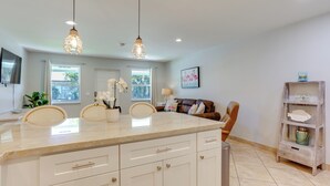 A spacious kitchen with a large island, two pendant lights, and a view of the living area. - 2 Mi to Swim & Shop: Updated North Palm Beach Home (Juno Beach)