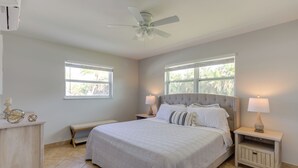 A bedroom with a bed, nightstands, a bench, and a ceiling fan. - 2 Mi to Swim & Shop: Updated North Palm Beach Home (Juno Beach)