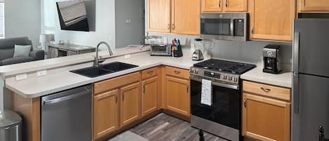 A modern kitchen with wooden cabinets, stainless steel appliances, and a built-in oven.