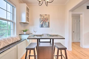 A kitchen with a dark countertop, two barstools, a potted plant, and a painting on the wall. - Cozy Mobile Condo w/ Community Outdoor Pool! (Mobile)